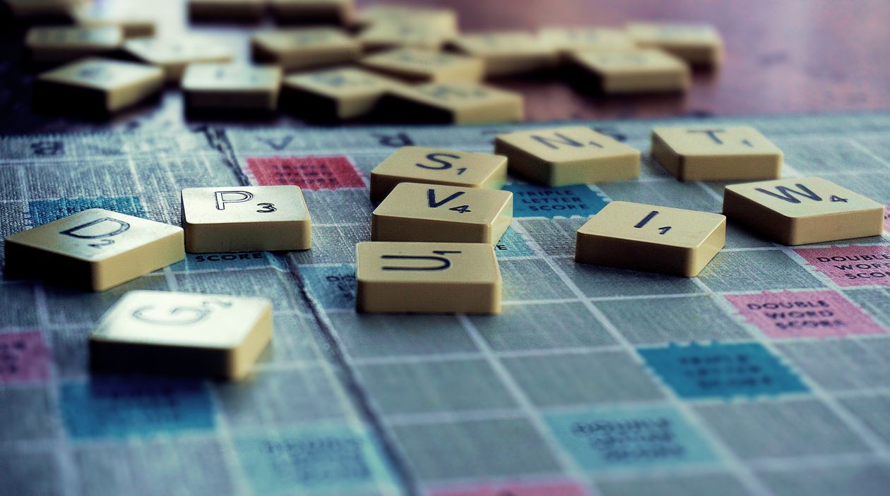 Close-up of a word game board showing a high-scoring play using premium squares