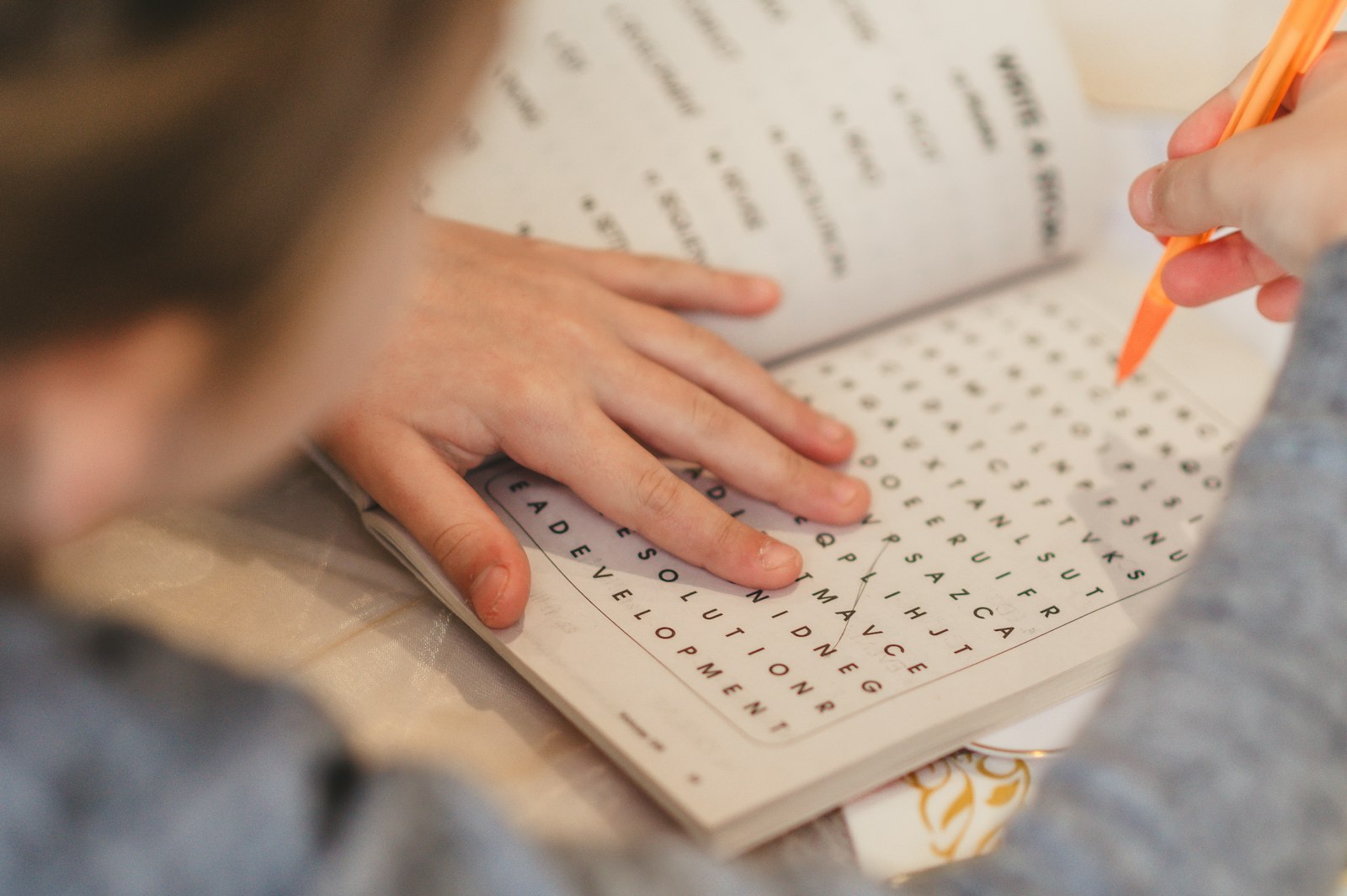 Scrambled Word Solver: Beat Any Puzzle Instantly 4 Child practicing spelling on a worksheet with a pencil